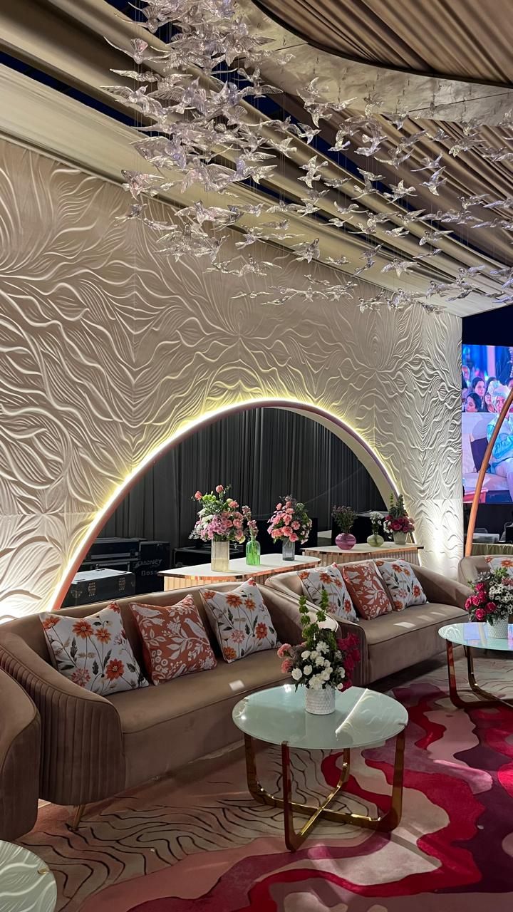 Lounge with sculpted wall, glowing arch and glass birds overhead